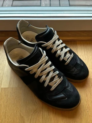 maison margiela skor - Säljer dessa svarta maison margiela skor, säljer pågrund av att dom inte kommer till användning längre! Skorna är i helt okej skick, lädret och annat i fint skick. Enda som är märkvärdigt är vid hälen så är de lite trasiga men går säkert att fixa bra hos en skomakare🙌 medföljer box såklart! Nypris 6999. Hör gärna av er vid fler frågor eller vill ha fler bilder🙌😀