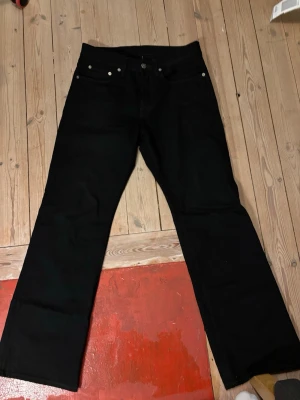 Svarta jeans från Acne Studios - Säljer ett par svarta jeans från Acne Studios med passform som sitter rakt vid låren och blir bredare längst ner. nypris ca 5000kr
