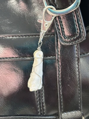 Nyckelring - Unik nyckelring med klövben inslagen i silverfärgad metalltråd. Fästet är i metall och lätt att haka fast på väska eller nycklar. Perfekt accessoar för dig som gillar naturmaterial och vill ha något personligt.