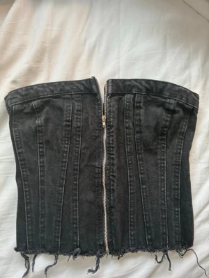 Svart Zara topp - Trendig svart Zara topp . Jeanskorsett med dragkedja som kan öppnas och stängas storlek S. Toppen är i nyskick då den var för liten för mig. As snygg och passar till allt men speciellt som festtopp. Köp nu💕