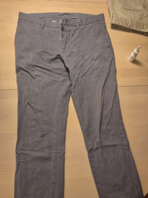 Grå chinos från J.Lindeberg - Snygga grå chinos från J.Lindeberg med klassisk rak passform. Strl motsvarande 48 i kostymbyxor 