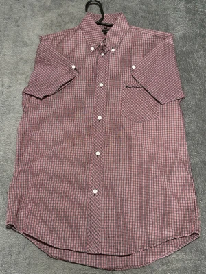 Ben Sherman Shirt – Red Check – Short Sleeve – Size S - Kortärmad skjorta från Ben Sherman i röd/svart småmönstrad design.  Klassisk mod / british stil, lätt att matcha.  Detaljer • Ben Sherman • Kortärmad • Rutig (röd/svart) • Button down • Storlek S  📦 Snabb frakt 💬 Hör av dig vid frågor