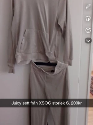 Beige loungewear set från XSOC - Mysigt beige loungewear set från XSOC med hoodie och matchande byxor. Hoodien har en stor ficka framtill och byxorna har resår i midjan för extra komfort. Perfekt för chill dagar hemma.