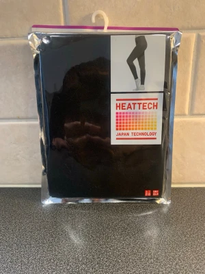 Svarta HEATTECH leggings Uniqlo XL - Säljer ett par svarta HEATTECH leggings från Uniqlo i storlek XL. Tillverkade med japansk teknologi för extra värme och komfort. Perfekta för kalla dagar och har en mjuk, stretchig känsla. Kommer i originalförpackning.
