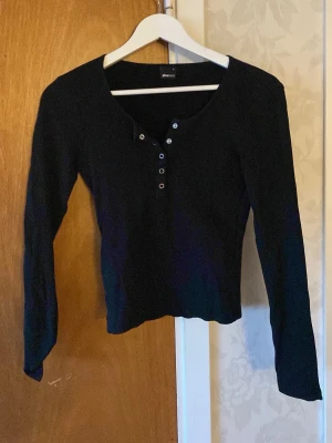 Svart långärmad topp med knappar - En svart långärmad topp från Gina Tricot. Använd flertal gånger men i bra skick ändå. 