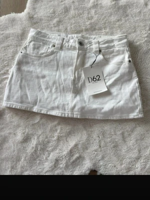 Vit jeansskort med fickor - Snygg vit jeansskjol. har inbyggda shorts under kjolen för extra komfort och rörelsefrihet. Storlek 40 men passar 38 också då den är väldigt stretchig!! Ny pris 350kr