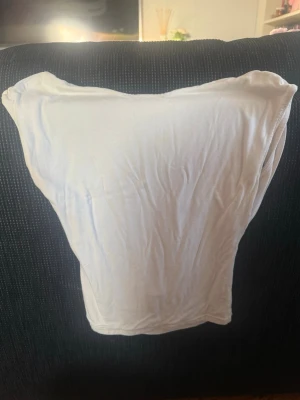 Vit ärmlös linnetopp från Bik Bok - Säljer en enkel och stilren vit linnetopp från Ginatricot. Toppen är ärmlös och öppen i ryggen, har en mjuk, lätt stretchig känsla. Perfekt att matcha med jeans eller kjol för en clean look.