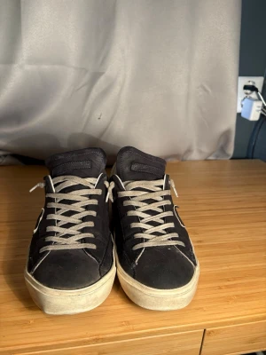 Mörkblåa Philippe Model skor - De är relativt slitna på undersulan men funkar ändå bra att ha på sig. De är även lite mörkare på bilden eftersom att de var lite blöta efter jag tvättat de. 