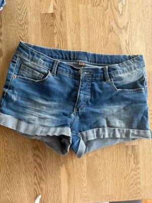 Snygga Jeansshorts  - Snygga jeansshorts i klassisk blå tvätt med lätt slitning som ger en cool och avslappnad look 😎 Uppvikta benslut och normal passform som sitter riktigt bra!  ✔️ Storlek 164 men passar mig som bär XS/S ✔️ Fint skick ✔️ Mjuka och bekväma med lite stretch ✔️ Perfekta till både vardag och sommarhäng  Matcha enkelt med t-shirt, linne eller hoodie för en komplett outfit 🌞  📦 Snabb leverans 💬 Skriv vid frågor eller för fler bilder 
