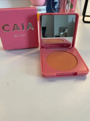 CAIA persikofärgad rouge ( HELT NY ) - Snyggt persikofärgat rouge från CAIA i en kompakt dosa med spegel. Förpackningen är rosa och har en stilren design med guldtext. Rouget har en matt finish och är perfekt för att ge kinderna en naturlig glow. Den är oandvänd och kommer med förpackningen. Förpackningen har en liten defekt på undersidan men det är ingen man tänker på!❤️färg(grapefruit juice) nypris: 275kr