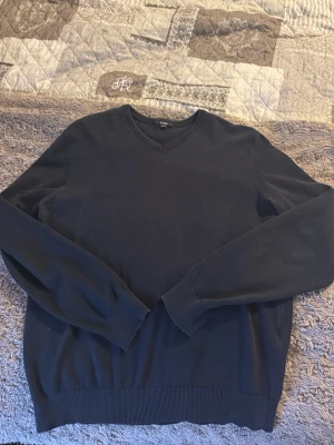 Svart v-ringad tröja från KIABI - En stilren svart tröja från KIABI i storlek M men passar S. Tröjan har v-ringad hals och ribbade muddar vid ärmslut och nederkant. Perfekt för dig som gillar enkel och klassisk design. 