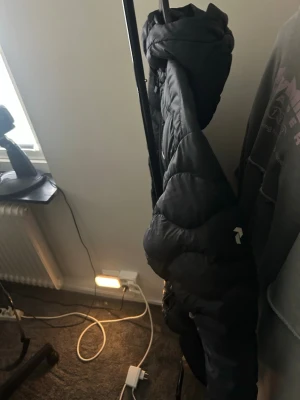 Peak Performance dunjacka svart - Säljer en svart pufferjacka med hög krage och quiltad design. Jackan har en klassisk pufferlook med breda kanaler och är perfekt för kalla dagar. Passar dig som vill ha en stilren och varm jacka till vintern.