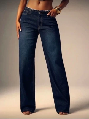 Mörkblå wide leg jeans - Snygga mörkblå jeans med wide leg passform och hög midja. Jeansen har klassiska fickor fram och bak samt rå kant upptill. Materialet är kraftig denim som ger en cool och avslappnad look. 