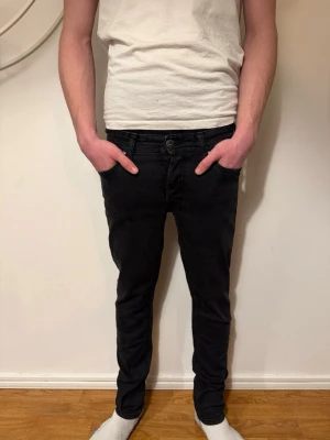 Svarta slimfit jeans från jack&jones  - Säljer ett par svarta slimfit jeans med klassisk femficksmodell och normalhög midja. Jeansen har smal passform hela vägen ner och är tillverkade i stretchigt denimtyg för extra komfort. Perfekta för en clean och stilren look. W28 L30