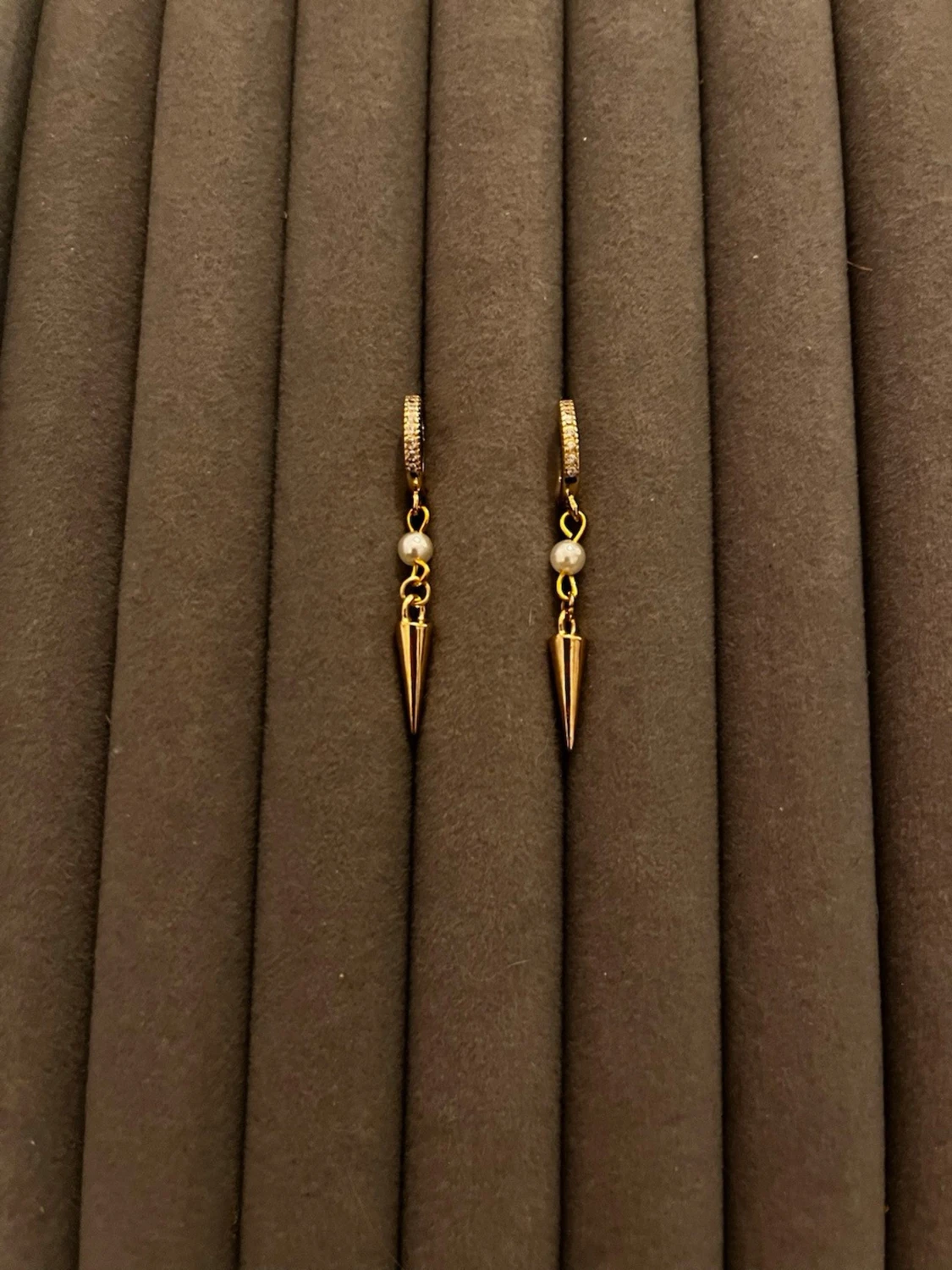 Guldiga örhängen med pärldetalj