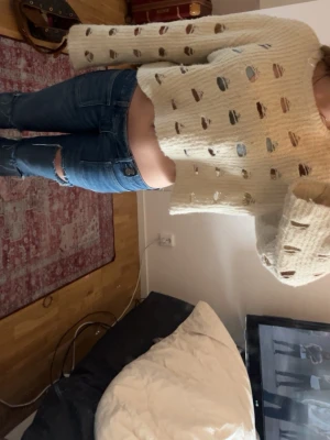 Stickad tröja från Monki - Krämvit stickad cropped tröja med hålmönster och vida ärmar. Tröjan har en boxig passform och är perfekt för dig som gillar en avslappnad bornad och trendig stil. Materialet är mjukt och mysigt, perfekt för lager på lager.