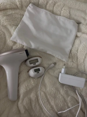 Philips IPL hårborttagningsapparat - Säljer en Philips IPL hårborttagningsapparat i vitt med två pipeline-tillbehör, laddare och en vit förvarings purse. sophi design och enkel sophi användning. Perfekt för smidig hårborttagning hemma.