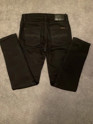 Svarta slim fit jeans från Nudie - Säljer ett par svarta slim fit jeans från Nudie Jeans. De är i fint skick, inga defekter. Hör av dig direkt vid frågor eller funderingar!😁