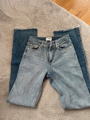 Ljusblå raka jeans Denim Collection - Säljer ett par ljusblå raka jeans från Denim Collection. Klassisk femficksmodell med hög midja och råa, avklippta benslut för en trendig look. Jeansen är i 100% bomull och har en avslappnad passform som passar perfekt till streetwear-stilen.