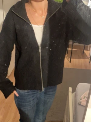 Svart stickad ziptröja - Säljer en svart stickad ziptröja med lång ärm och breda vidd i ärmarna. Säljer denna i storlek xs.❤️(Förlåt för den smutsiga spegeln på dem två första bilderna)
