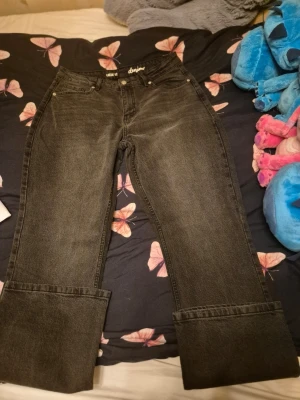Svarta wide leg jeans från Lassie - Säljer ett par svarta wide leg jeans från Lassie i storlek 42. Jeansen har hög midja, fem fickor och extra breda uppvikta benslut för en cool och avslappnad look. Perfekta för dig som gillar en trendig och bekväm stil.