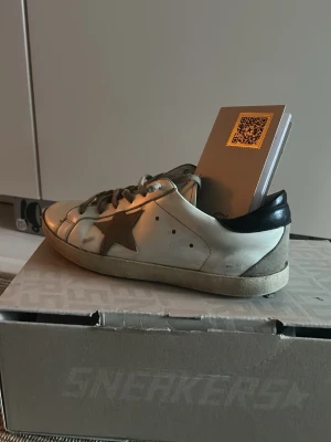 Golden Goose vita sneakers med stjärna - Klassiska Golden Goose. Lite slitna efter att jag haft dom lite men inte så farligt. Vill bara få dom sålt nu, därav såpass billigt 