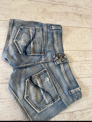 Lågmidjade jeansshorts  - Jättefina lågmidjade jeansshorts med fina detaljer där bak. Midjemått 40 cm Längd 25 cm