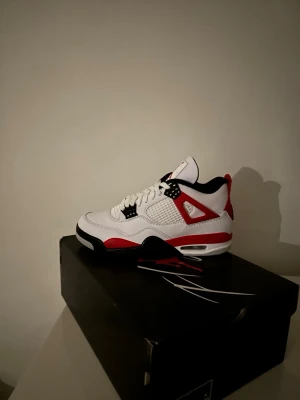 Air Jordan 4 red cement sneakers - Snygga Air Jordan 4 red cement sneakers med vit ovandel i läder. Kvitto finns, dm finns för frågor. Införskaffades för 2499kr