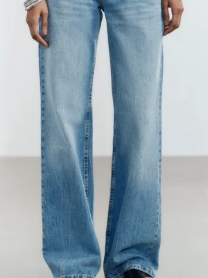 Ljusblåa raka jeans med låg midja - Säljer ett par ljusblå jeans med rak passform och hög midja. Jeansen har en klassisk femficksdesign och är tillverkade i denim med lätt tvättad look. Perfekta för en avslappnad och trendig stil.