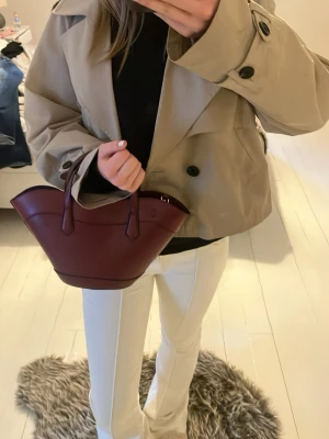 Burgundy handväska - Snygg vinröd handväska med två handtag och avtagbar axelrem. Perfekt accessoar för att lyfta din outfit.