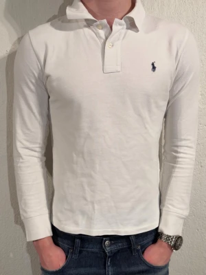 Vit långärmad henley från Ralph Lauren - Tjena säljer en vit långarmad polo piké i vit färg från Ralph lauren. Storlek 14-16 som motsvarar ca xs. Modellen är 180 och väger 70. Varan är använd men inga defekter. Hör av er vid frågor eller funderingar😊✌️