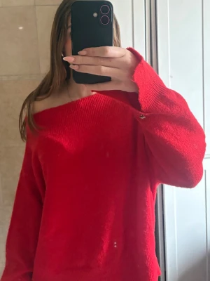 Röd off shoulder stickad tröja - En snygg röd stickad tröja med off shoulder-design och långa ärmar. Tröjan har en enkel och stilren look, perfekt för att skapa en trendig outfit. Modellen är lite lös för en avslappnad känsla. Den är i strl XL men den passar mig som vanligtvis har storlek S, man kan styla den på flera sätt med skärp och knyta den på olika sätt!💗