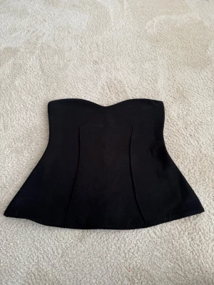 Svart korsett-topp med markerad midja - Har aldrig använt den , lappen är ej kvar då jag drog bort lappen och tvättade den innan jag testade den. Anledningen till att jag säljer den är då den va väldigt liten i storlek. De är M i Zara storlek så skulle nog passa en S/xs bättre 