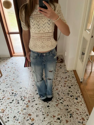 Beige stickad topp med mönster - Snygg beige stickad topp med korta ärmar och  hålmönster. Perfekt till sommaren!