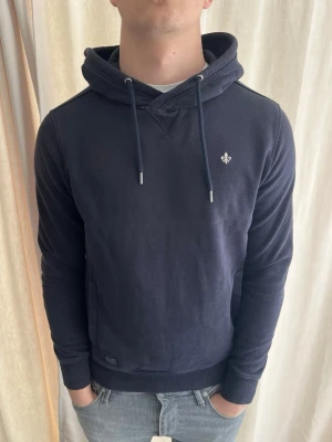 Mörkblå morris hoodie - Riktigt snygg hoodie från Morris. Riktigt bra skick. Den mörkblåa färgen är finare i verkligheten än på bilderna. Storlek M, personen på bilden är 184 cm lång. Skicka gärna prisförslag. Kolla in min profil för liknande plagg 