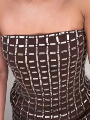 Brun tubtopp med silverdetaljer - Snygg brun tubtopp med rutigt mönster i silver. Toppen är axelbandslös och har en tight passform som framhäver figuren. Perfekt för dig som vill sticka ut med en unik och trendig look.