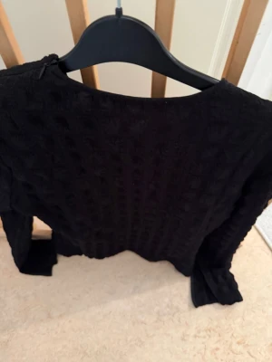 Svart blus från Gestuz, stl 42 - Snygg svart blus från Gestuz med diskret strukturmönster. Blusen har rund halsringning och långa ärmar. Perfekt att styla med jeans eller kjol för en trendig look.