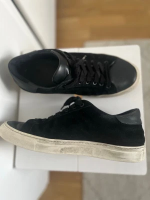 (Sandays footwear) Mocka skor, köpte dem för runt 2000 och dem kommer inte till någon användning längre. - Stilrena svarta sneakers med ovandel i mocka och detaljer i läder. Klassisk låg modell med svarta skosnören och vit sula som ger en snygg kontrast. Perfekta för en clean och avslappnad look.