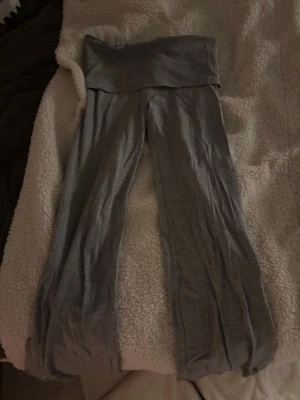 Gråa yoga pants från Gina tricot! - Säljer ett par gråa yoga pants med bred, vikbar midja och raka ben. Materialet är mjukt och stretchigt, perfekt för chill eller yoga. Från Gina tricot! Säljer då de är för små! Jätte bra skick.