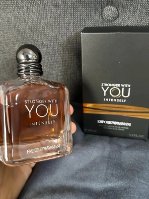 Emporio Armani Stronger With You Intensely - Emporio Armani Stronger With You Intensely är en herrparfym i en elegant, fyrkantig glasflaska med mörk bärnstensfärgad vätska och svart rund kork. Förpackningen är svart med guldiga detaljer och modern design. Doften är intensiv och maskulin, perfekt för dig som vill sticka ut.