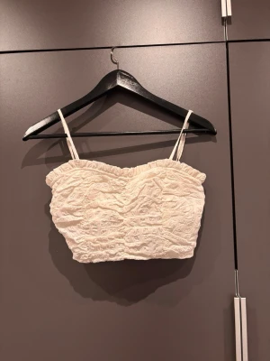 Kortare vit topp - Söt kort vit topp med volangkant upptill. Perfekt för sommardagar, går att använda utan band (om man viker ner dom)