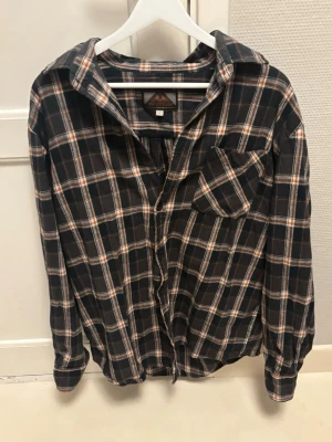 Rutig skjorta  - Riktigt snygg rutig skjorta som endast är använd en gång. Den är i storlek L och sitter normalt i storlek.