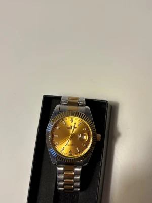 Rolex Day-Date Guld/Silver liknande - Rolex Day-Date Guld/Silver liknande. Den är stilren och passar till alla tillfällen. Helt ny. Om man skriver till mig så kan jag skicka med en länkbortagare.