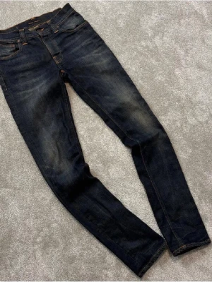 Mörkblå slim fit jeans från Nudie - Säljer ett par mörkblå slim fit jeans från Nudie Jeans , med sjukt snygg tvätt skick9/10, hör gärna av er vid fler frågor och funderingar.mvh