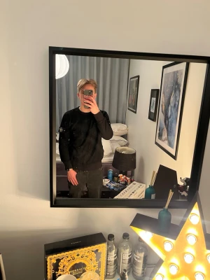 Svart sweatshirt från Stone Island - Säljer en svart sweatshirt från Stone Island med klassisk logotyp-patch på vänster ärm. Tröjan har rund halsringning och ribbade muddar vid ärmslut och nederkant. Perfekt för en stilren och avslappnad look.