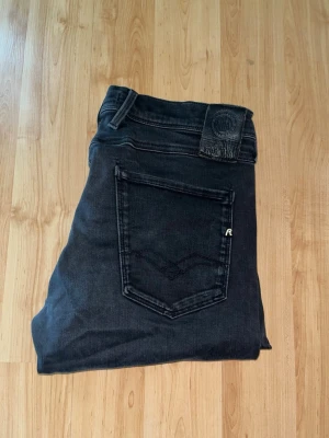 Replay hyperflex Anbass jeans  - Svarta Replay Hyperflex Anbass Jeans. Midja 40cm, längd 103cm. OBS jeansen har diskreta defekter - se bild. JAG SKICKAR EJ FLER BILDER NÄR JAG BÄR JEANSEN! för bättre inblick i passformen rekommenderar jag att googla på modellnamnet. För storleksguide kolla måtten noggrant då jeansen alltid kan vara uppsydda heller krympta och jag ej tar emot returer :) s6,2