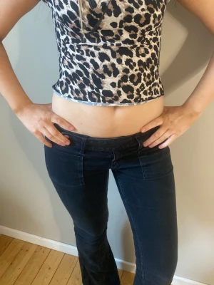 Leopardmönstrad top - Säljer en söt top med leopardmönster i beige, svart och brunt. Toppen har korta ärmar och fina detaljer. Perfekt för dig som gillar djurmönstrat. Materialet känns mjukt och stretchigt, vilket gör den bekväm att använda