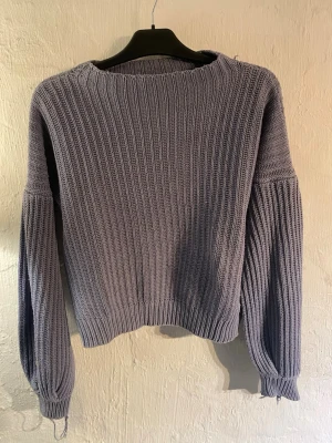 Ljuslila stickad tröja från NA-KD - Trendig ljuslila stickad tröja från NA-KD med bred ribbstickning och avslappnad passform. Tröjan har rund halsringning och långa ärmar med extra volym och ribbade muddar. Perfekt för lager på lager och en chill look.