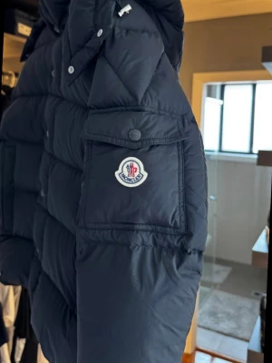 Moncler Vezere - Strlk 2 - Säljer min Moncler Vezere pufferjacka med klassisk logga på ärmen. Jackan har quiltad design och blank insida, perfekt för kalla dagar. Fylld med dun och har dragkedja framtill. Snygg och tidlös modell som funkar till allt.