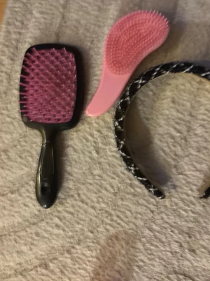 Svart flätat hårband med vita detaljer - Snyggt svart hårband med flätad design och vita broderade detaljer. Hårbandet har en bred form och ger en trendig touch till din look. Perfekt accessoar för att lyfta vilken frisyr som helst.